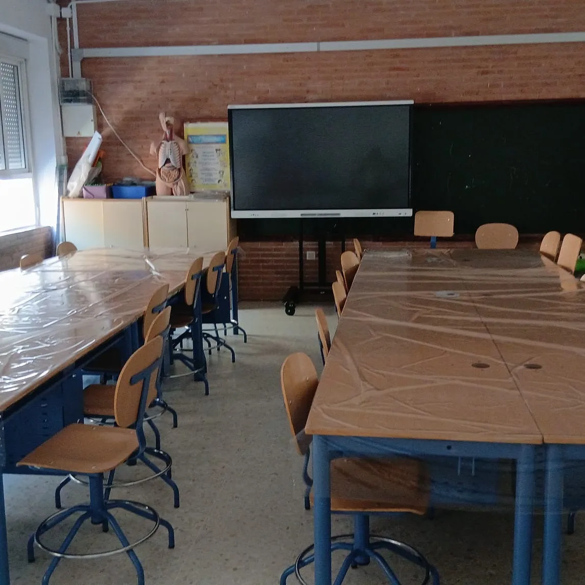 Aula con pizarra digital y mesas de trabajo