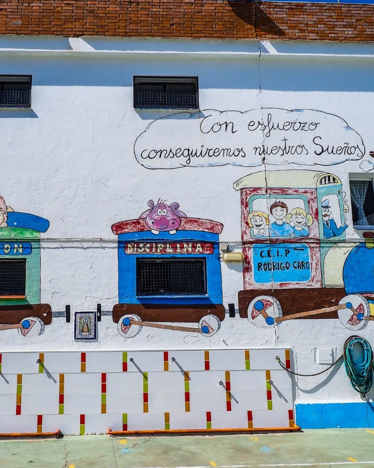 Fachada del patio del CEIP Rodrigo Caro con el lema Con esfuerzo conseguiremos nuestros sueños
