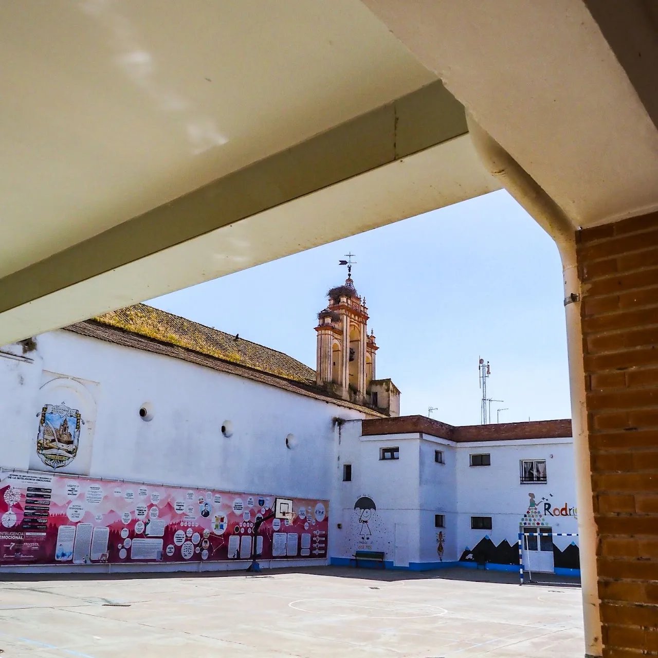 Patio del colegio con la torre de la iglesia al fondo