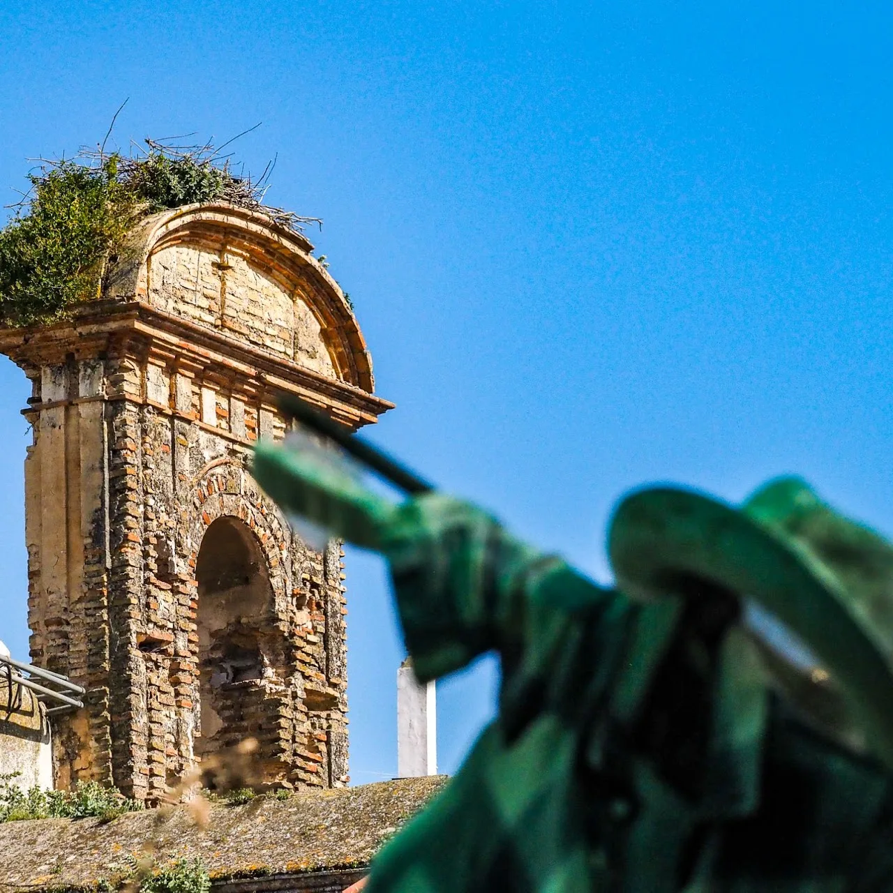 La torre de la iglesia y la escultura del patio